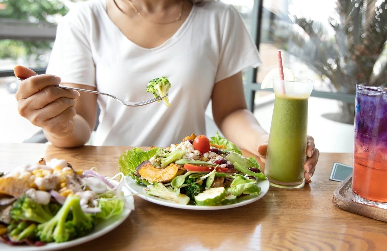 une femme mange un repas composé de légumes